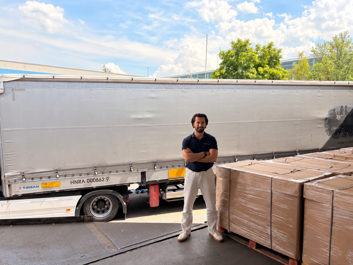 Onur Yılmaz beside a truck and packed goods during earlier logistics fieldwork